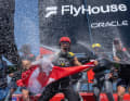 … la regata amichevole di venerdì, prima del weekend di gara, ha visto Ryan Reynolds, anch’egli comproprietario dei Bonds Flying Roos, a bordo dell’imbarcazione canadese del Team NorthStar con il timoniere Giles Scott. Qui Reynolds festeggia alla grande la sua vittoria con dello champagne Rothschild.
