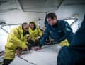 Kevin Escoffier e l'equipaggio preparano una toppa per uno strappo nella vela