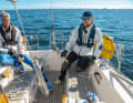 2. furling the mainsheet, man on the reefing eye: furl the mainsheet so far that the pressure is off the sail but it does not beat too strongly. The co-sailor goes forwards to attach the reefing eye to the boom later, if required. Another crew member makes the halyard ready to release