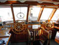 The bridge with two helm stations behind thick safety glass. The companionway leads into the owner's area