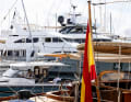 Una vista suggestiva che spazia dai tradizionali velieri in legno ai moderni yacht mostra la varietà di imbarcazioni che si riuniscono sotto la bandiera spagnola nella baia di Palma.