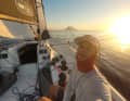 Golden Hour auf See: Paul Piendl vor malerischer Vulkan-Kulisse. Solche Momente auf dem Wasser lassen den Reiz des Offshore-Segelns immer wieder aufleben.