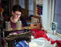 Small and large national flags: Katja Fromm sews different coloured fabrics into a flag in several steps in the workshop