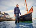 Exiled Brit Roger Barnes in front of his Ilur "Avel Dro" in its home port of Douarnenez