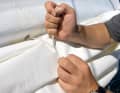 5. fissare la vela in eccesso: Se la vela è stata ridotta al secondo o addirittura al terzo terzarolo, in coperta ci sarà molto tessuto che sventola al vento. Il modo migliore per fissarlo è utilizzare gli occhielli dotati di cinghie. Importante: non dimenticate di allentarli prima di srotolare la vela, altrimenti gli occhielli si strapperanno!