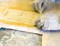 Une couche de tissu en fibre de verre de 163 grammes est encore posée pour stabiliser le tout. Après le durcissement, la face inférieure du couvercle est grossièrement poncée avec du papier de 36.