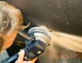 The screw connections on old through-hulls are usually seized up, so simply grind off the protruding part with an angle grinder. Slipping off is not a problem, the hole has to be ground open further anyway