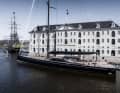„Nilaya“ neben dem Amsterdamer Schifffahrtsmuseum, achteraus von der Replik eines Ostindienfahrers