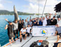L'équipage de "Raven" célèbre sa victoire au temps de course avec un trophée et un foil tribord.