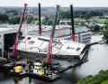 Four mobile cranes arrived to turn the aluminium hull, two of which were parked on pontoons