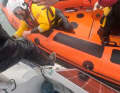 The skipper climbs into the lifeboat.