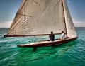The huge gaff mainsail with its boom projecting far beyond the stern characterises the silhouette of the antique racing yacht