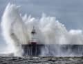 Waves crash against the harbour wall of the Newhaven lighthouse in Newhaven, Great Britain