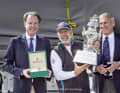 Le skipper "Alive" vainqueur Duncan Hine (au centre) avec les organisateurs et les hôtes lors de la remise des prix