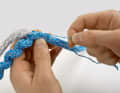 Two centimetres behind the exit, a card is pulled out of the casing. It will later serve as a sewing thread