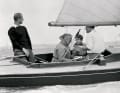 Uffa Fox (2nd from left) with Prince Philip (at the tiller) and Prince Charles (2nd from right)