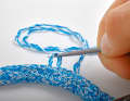 Flatten the sheath braid and unwind the yarn strands at one edge with the awl, making sure that they are only pulled out of the short end