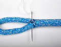 Finally, the splice is secured with five to six stitches. Instead of rigging yarn, a yarn from the sheath offcut is used for this. It matches the colour perfectly and the fibres are parallel, so they fit together perfectly.