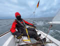 Wrapped up thickly against the cold wind, Julia Harder steers the J/22 through the short winter day