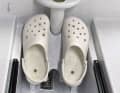 Simple Kunststoff-Crocs, festgeschraubt auf der Fußstütze der Ruderbank, sollen Halt bieten 