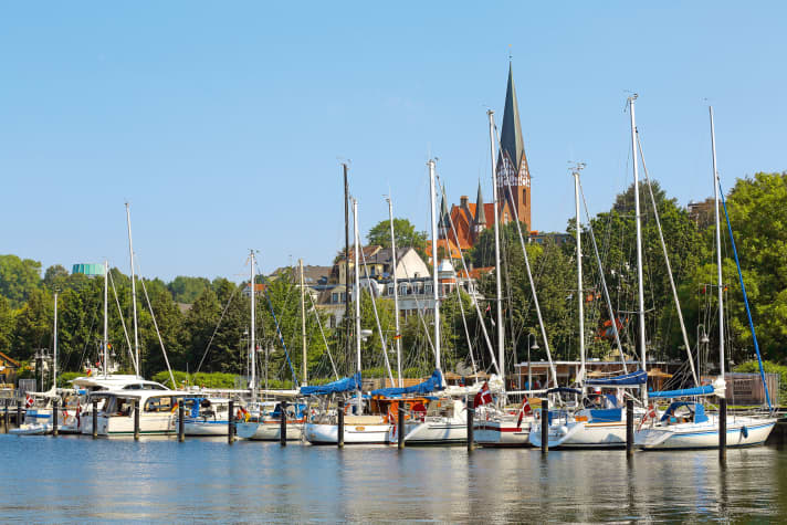 Die Stege des Stadthafens im Zentrum von Flensburg mit der Kirche 
St. Jürgen im Hintergrund