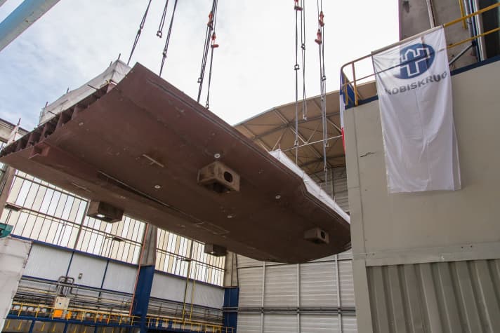 Der Portalkran hob die 80 Tonnen schwere Bodensektion in die Schiffbauhalle. | e.