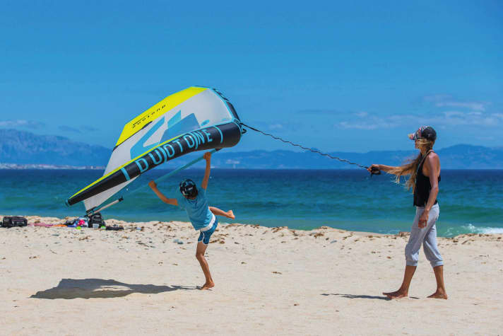Das Handling des Wings lernen Kinder am besten spielerisch am Strand