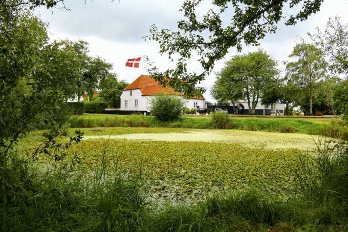 Weiß getünchtes Bauernhaus im beschaulichen Inseldorf. Birkholm ist beinahe so flach wie das angrenzende Wasser der Dänischen Südsee 