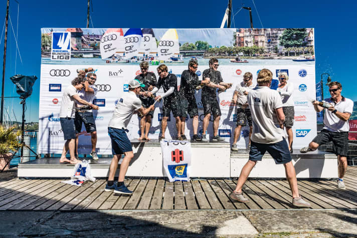   Wenn die Zweitligisten feiern: Siegerehrung mit der Crew des Flensburger Segel-Clubs auf dem höchsten Podestplatz. Das Podium gehört in Lindau drei norddeutschen Clubs