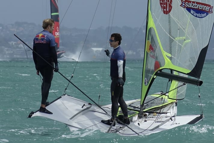   Im Traumrevier vor Auckland: Erik Heil und Thomas Plößel beim Training. Im Hintergrund ist die neuseeländische Cup-Yacht mit Peter Burling am Steuer zu sehen