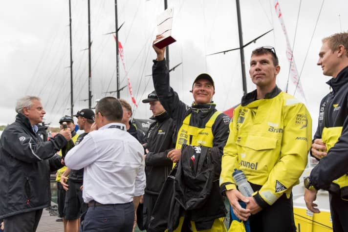   Da freut sich einer: "Brunel"-Skipper Bouwe Bekking mit dem Siegerpokal für das Hafenrennen von Lissabon und einem Teil seiner Crew