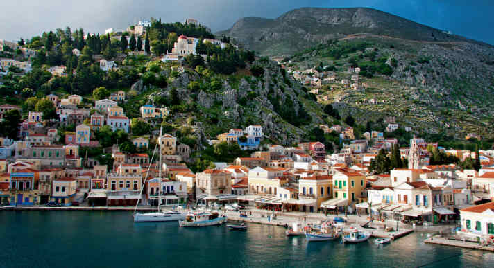 Vue sur le port de Symis avec des maisons aux couleurs pastel. Le fond est profond, beaucoup de chaîne coincée !