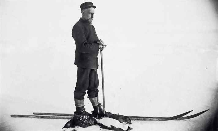 Roald Amundsen posa sugli sci di fronte ai suoi pinguini uccisi