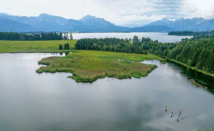 Idyllisch eingebettet liegen der Forggensee (Hintergrund) und Illasbergsee (Vordergrund) im Allgäu.
