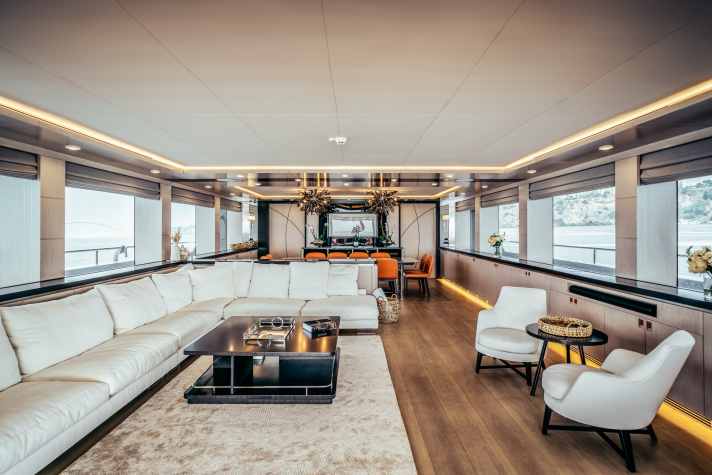 Cremefarbenes Ensemble von Flexform aus Couch und Sessel im Salon, dazu Akzente in Orange.