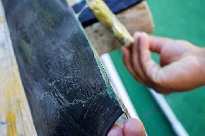 Coat one long edge of the topping well with adhesive.