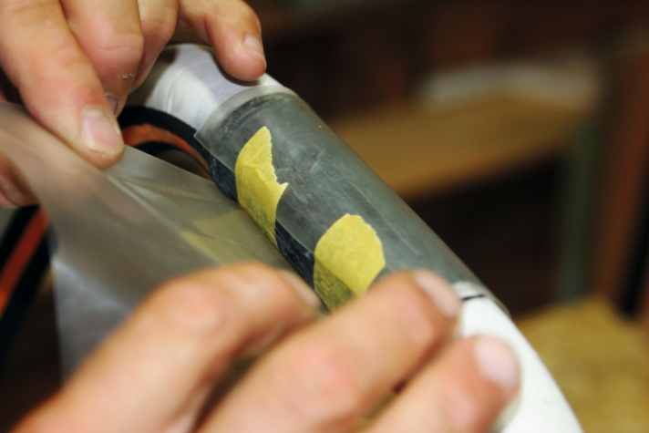 Pull it tight and secure the rubber with a strip of Tesa masking tape.
