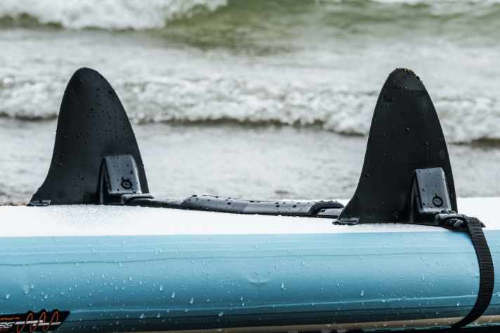   Der Add On Drift Stopper wird einfach mit einem Spanngurt um das SUP geschnallt