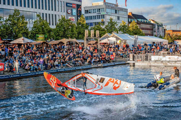 Freestyle mitten in der Stadt beim Tow-In am Bootshafen auf der Kieler Woche
