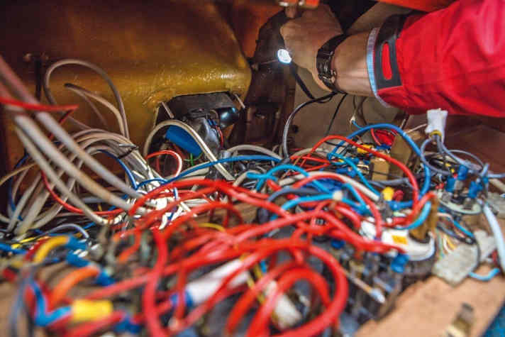 Non così: dietro il pannello degli interruttori si scopre un impenetrabile groviglio di cavi.