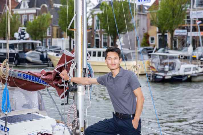   Solo sailor Li on the foredeck of his boat