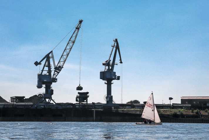   Industrie-Idyll mit Pirat. Die "Timpe Te" segeln Vater Sören und Tochter Maja Sander vom Düsseldorfer Segler-Verein