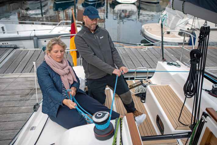 Ein Crewmitglied fällt in die Schot ein, der Trimmer zieht die Schot ab