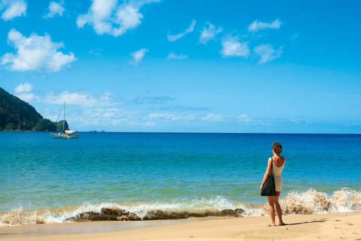 Angekommen. Claudia Clawien blickt vom karibischen Sandstrand der Pirate’s Bay von Tobago aus auf ihre dort vor Anker liegende stählerne Segelyacht „Inti“