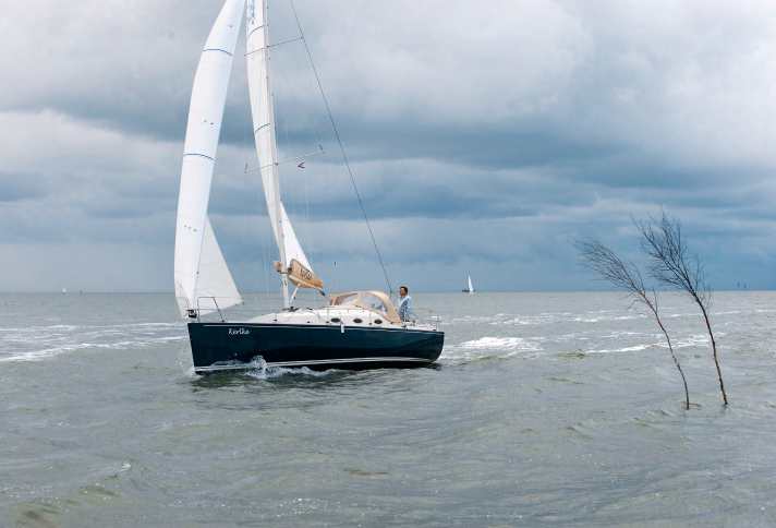 Eine Fahrtenyacht passiert ein mit Pricken bezeichnetes Wattenhoch. Die drei heutigen Nationalparks an der deutschen Nordseeküste sind traditionelle Segelreviere