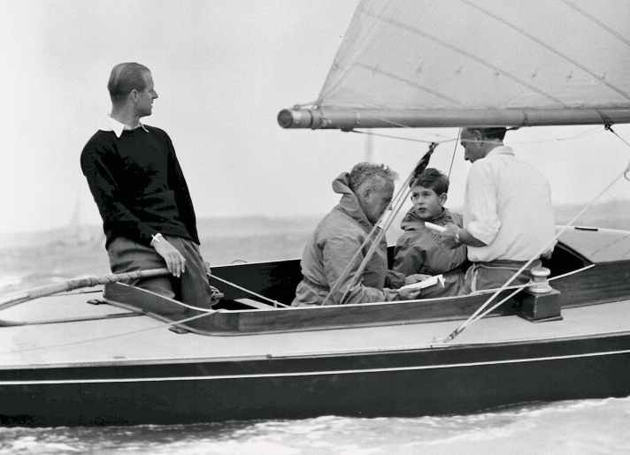 Uffa Fox (2. v. l.) mit Prinz Philip (an der Pinne) und Prinz Charles (2. v. r.)