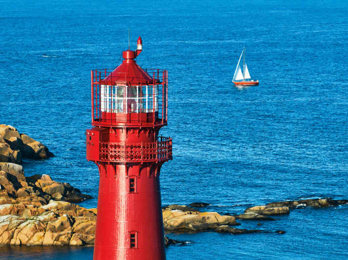 Naviguer sur la côte sud de la Norvège L'île de Svenner avec un phare et un port naturel sécurisé et de belles côtes avec des rochers et des plages sur la côte sud de la Norvège.