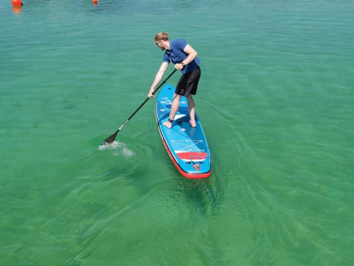 The paddle must be dipped as far away from the board as possible. To do this, the overreaching arm is extended and initiates the tack. The position of the feet remains the same for a secure stance.