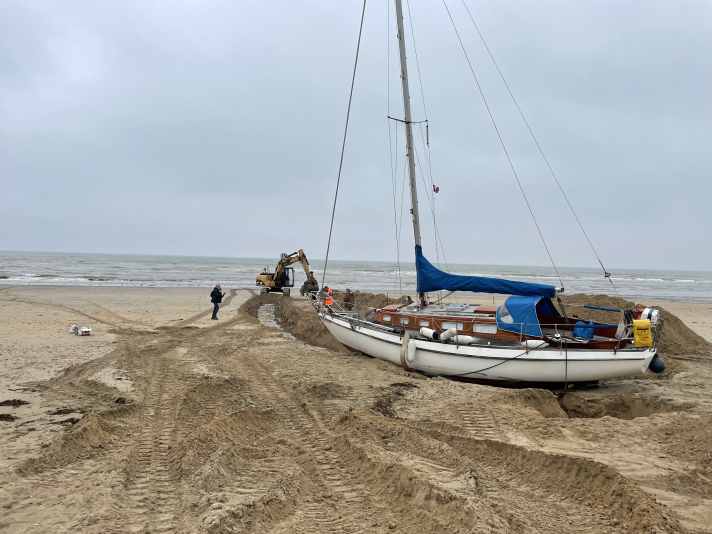 Ein Trupp hilfsbereiter Anwohner bewegte Ende April mit einem Bagger tonnenweise Sand. Durch den vierzig Meter langen Graben konnte bei Springflut ausreichend Wasser zum Schiff gelangen. Nach vier Wochen hoch und trocken auf dem Strand ist es inzwischen wieder flott - und nahezu unbeschädigt.