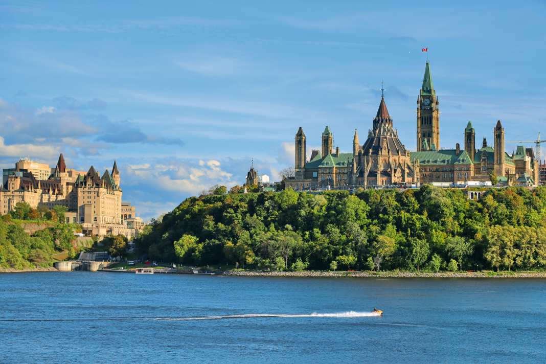 Imposanter Auftakt: Blick über den Ottawa River auf Parliament Hill, das politische Herz Kanadas. Links daneben ist die Schleusentreppe von Ottawa zu erkennen – der Beginn des Rideau Canals